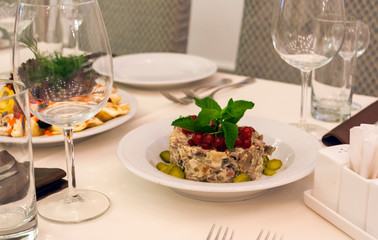 Russian salad with mushrooms and red currants on the holiday table