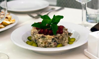 Russian salad with mushrooms and red currants on the holiday table