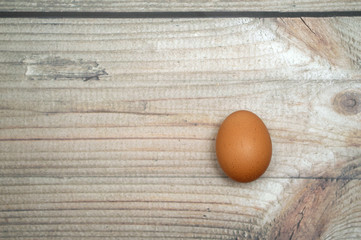 Raw chicken egg on a wooden background