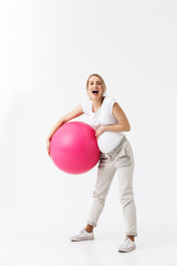 Beautiful young pregnant yoga fitness woman posing isolated over white wall background make exercises with ball.