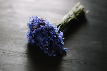 bouquet of cornflowers on a dark background. wedding details, bridal bouquet