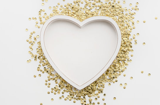 Heart shaped white photo frame with golden sparkles. Romantic concept mockup