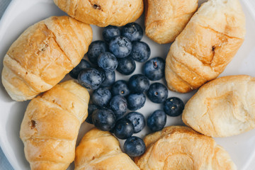 healthy light breakfast. blueberries, croissants on a plate. close up, top view. proper nutrition for a slim figure. raw food vegetarianism. diet