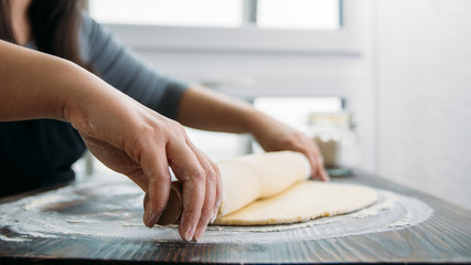 Unrecognizable woman rolling dough. Close Up