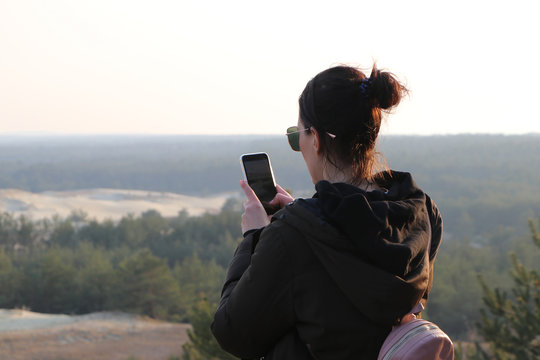 woman blogger photographing on the smartphone sand dunes during sunset and publishes in social network - Powered by Adobe