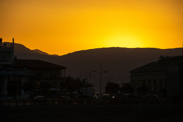 Fototapeta na wymiar Greece, Crete, August 2018: Sunset in the city of Heraklion behind the mountains
