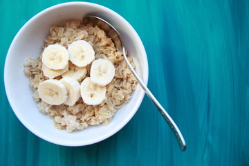 oatmeal with banana in white bowl, healthy breakfast