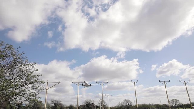 Airplane flying low during approach at London Heathrow airport - Big aircraft seen from below in slow motion - Travel and transportation in the busiest airport in Europe