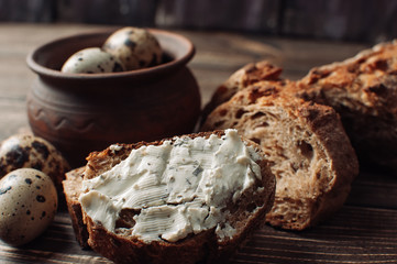 Bread on a wooden table with cheese and eggs