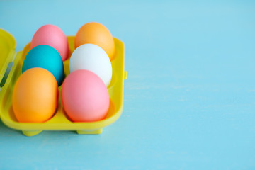 Easter painted eggs on a blue wooden table in tray. soft focus. Happy Easter