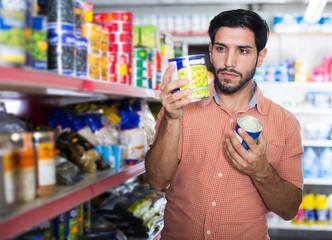 Man is choosing canned peas