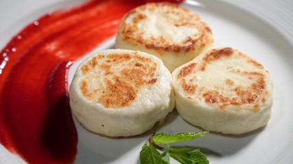 Three cheese pancakes on a plate with sauce