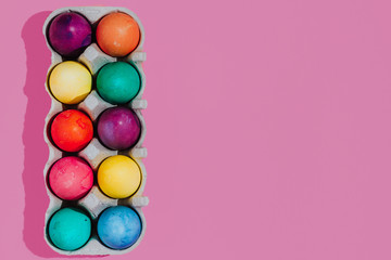 Easter background with Easter eggs. Top view with copy space. multicolored Easter eggs on a pink background