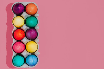 Easter background with Easter eggs. Top view with copy space. multicolored Easter eggs on a pink background