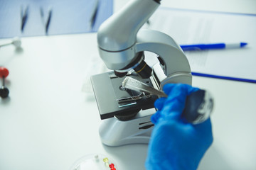 Scientist putting medical powder on microscope slide in laboratory