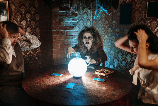 Witch reads scary spell over a crystal ball