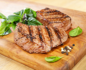 grilled beef steak on a cutting board with spices .