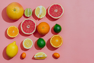 tropical and  citrus fruit sliced  over light pink background. Pastel style. top view. space for text.
