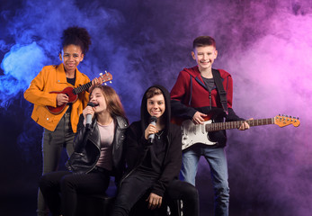 Band of teenage musicians on dark background