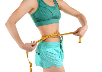 Sporty woman with measuring tape on white background