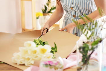 Obraz na płótnie Canvas Young florist making bouquet in shop, closeup