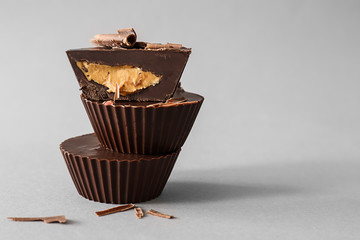 Tasty chocolate peanut butter cups on grey background