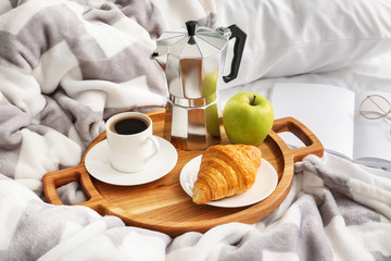 Fototapeta na wymiar Tray with tasty breakfast on bed