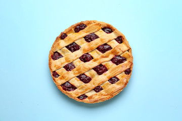 Tasty cherry pie on color background