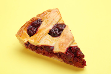 Piece of tasty cherry pie on color background