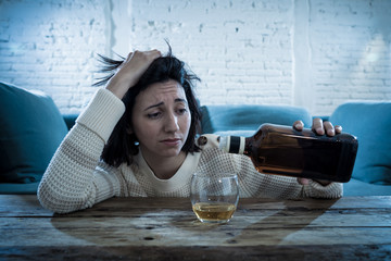 Young, sad, unhappy, helpless woman drinking alcohol. Human emotions, alcoholism and addictions