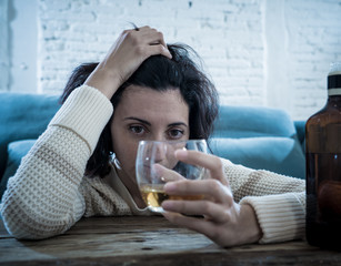 Young, sad, unhappy, helpless woman drinking alcohol. Human emotions, alcoholism and addictions