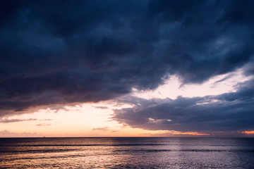 Naklejka na ściany i meble spectacular sunset on a beach with stormy sky