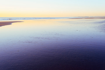 beach flooded by low tide at sunset
