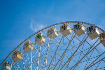 Big wheel against the background of the blue sky and an old city architecture Kiev, Ukraine. Amusement park. Area.