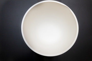 A bowl for kneading the dough with a white bottom is on the table