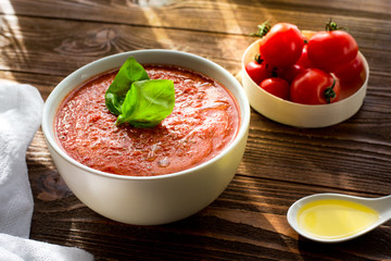 Tomato soup and basil. Cherry. Oil. Wooden. Homemade. Dinner. Paleo diet.