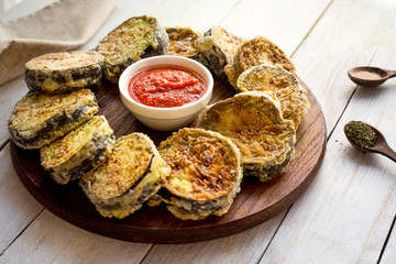 Baked Zucchini with Parmesan and sauce. Homemade. Top view. Wooden white table. Ingridients. Spices. 