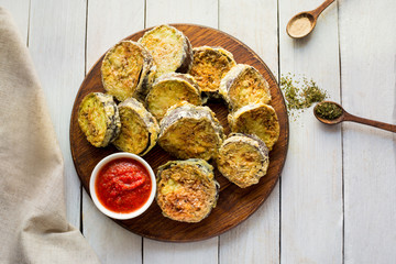 Baked Zucchini with Parmesan and sauce. Homemade. Top view. Wooden white table. Ingridients. Spices. 
