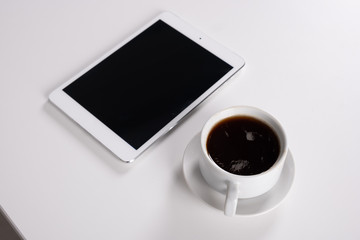 Fototapeta na wymiar digital tablet and coffee cup on wite table