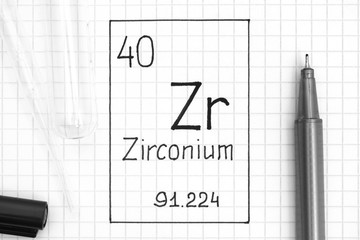 Handwriting chemical element Zirconium Zr with black pen, test tube and pipette.