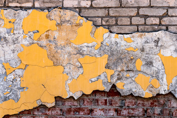 Vintage yellow wall texture with red and white bricks. Cracked paint on grunge background.