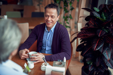 Happy elegant mature man have meeting in cafe
