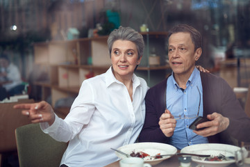 Mature couple looking from window of cafe