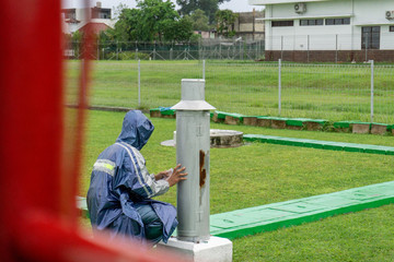 BALI/INDONESIA-DECEMBER 21 2017: A meteorological observer checks the Helman rain meter at...