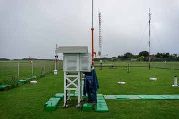 BALI/INDONESIA-DECEMBER 21 2017: A meteorological observer checks the meteorological cage at meteorology garden to make sure tools on that cage work well on the rainy day
