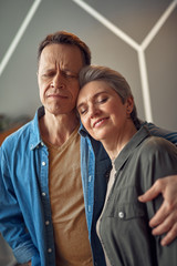 Happy aged couple embracing with gentle hands