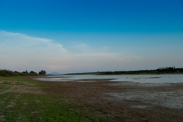 Coastal when water levels decrease in summer with evening sky at Dok Krai reservoir Rayong Thailand.