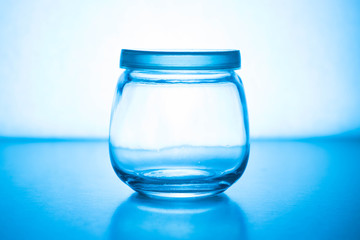Empty glass jar on a blue background