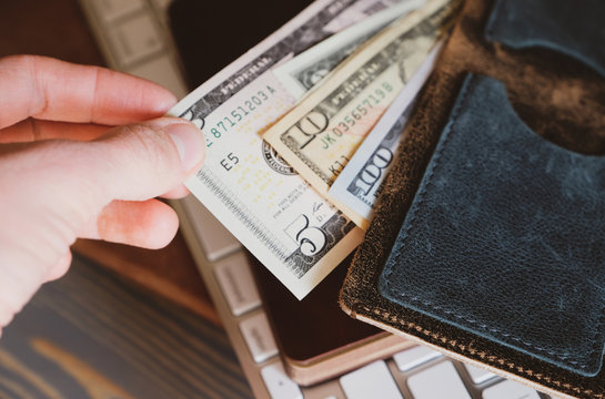 Unrecognizable person takes money from a wallet