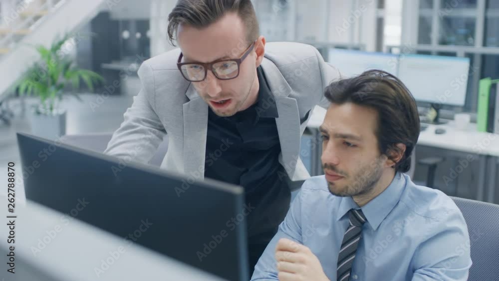 Aufkleber In Bright Modern Office: Handsome Office Worker Sitting and Working at His Desktop Computer, Discusses Problem Solution with His Project Manager. Team of Businessmen Planning and Problem Solving